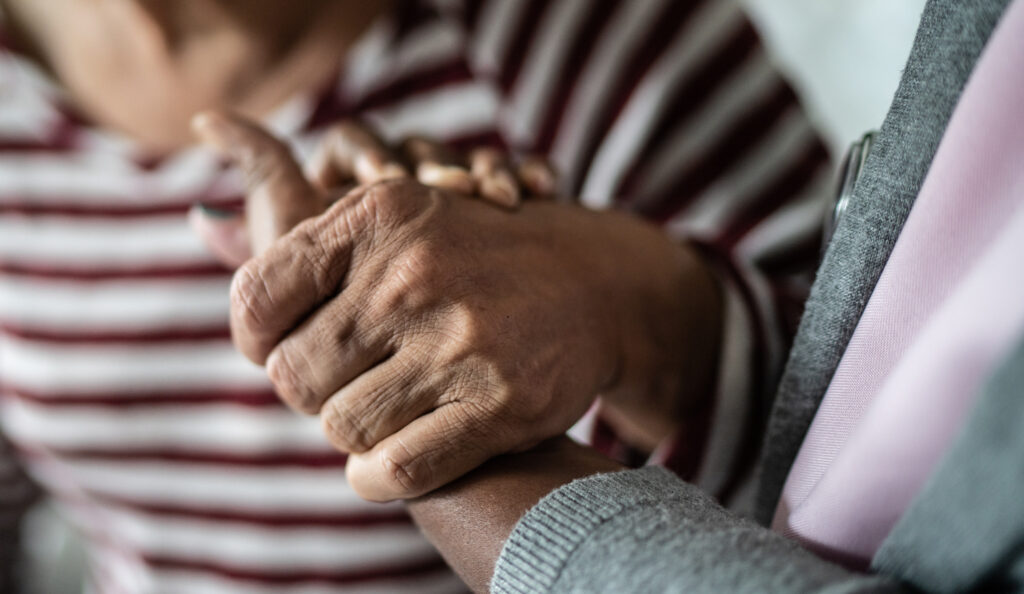 Elderly person holding hands
